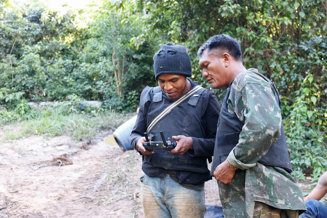 O líder indígena Paulo Paulino Guajajara, à esquerda, e o cacique Olímpio Iwyramu Guajajara, à direita, ambos “Guardiões da Floresta”, monitoram um drone na Terra Indígena Arariboia, no Maranhão. Imagem cortesia de Sarah Shenker/Survival International.